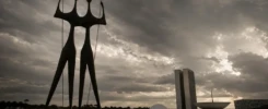 A imagem feita por IA mostra Os Candangos diante do Congresso Nacional (num angulo arquitetado pela IA), em Brasília, sob um céu pesado e dramático, criando uma atmosfera de tensão política, desencanto e desgaste institucional.